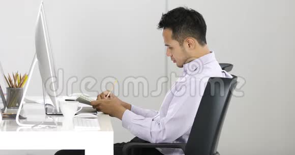 坐在电脑前的亚洲商人视频的预览图