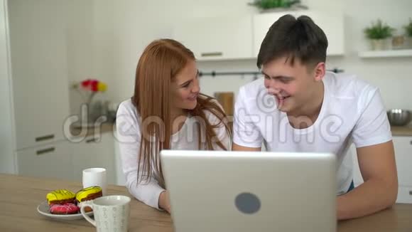 白人夫妇在厨房用电脑家庭技术和人际关系概念微笑视频的预览图