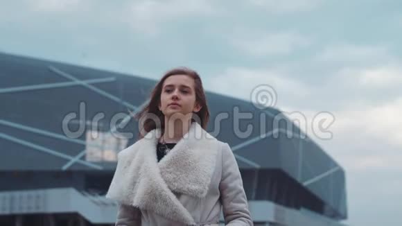 漂亮的欧洲年轻女孩穿着一件温暖的外套在机场闲逛很漂亮的女孩风的天气风的嬉戏视频的预览图
