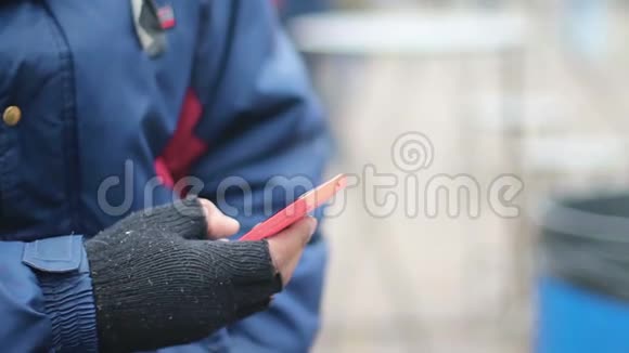 男性使用触摸电话用旧无指手套穷人发短信视频的预览图