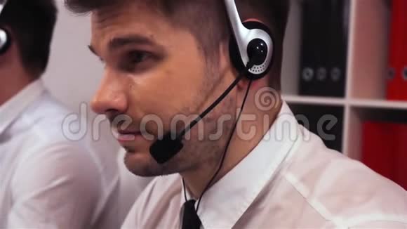 两名带耳机的员工在语音呼叫中心交谈视频的预览图