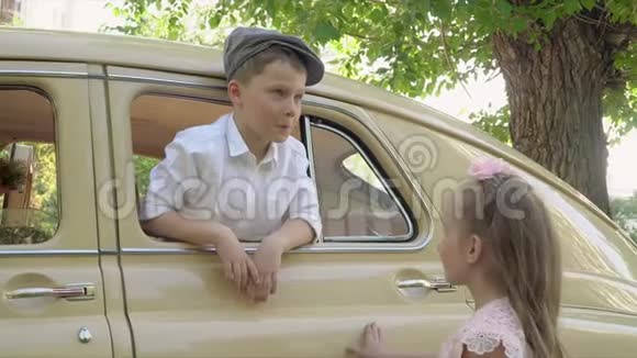 小男孩和妹妹在复古车上摆姿势拍照视频的预览图