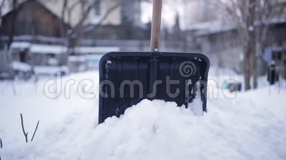 打扫完院子里的雪后女人把铲子放进雪里视频的预览图