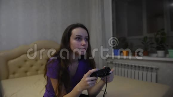 女孩游戏玩家一边玩游戏本一边看着面前的屏幕视频的预览图