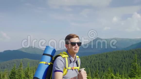 一个背着背包的年轻人上坡健康快乐的山区游客画像视频的预览图