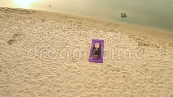 无人驾驶飞机的空中景观一个年轻的女孩在河边练习瑜伽视频的预览图