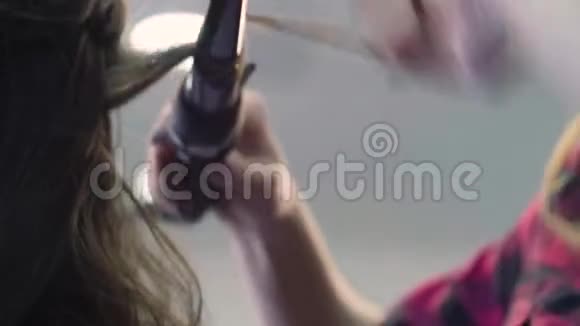 造型师用卷发钳卷发的手视频的预览图
