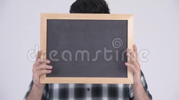 年轻快乐的留着胡子的印度男人一边看黑板一边微笑视频的预览图