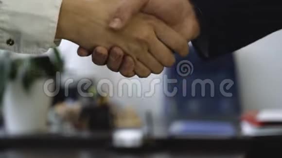 办公室背景下的握手特写良好的商业交易与握手建立了伙伴关系两个同事视频的预览图