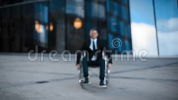 城市里坐轮椅的快乐商人视频的预览图