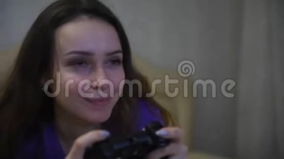 女孩游戏玩家一边玩游戏本一边看着面前的屏幕视频的预览图