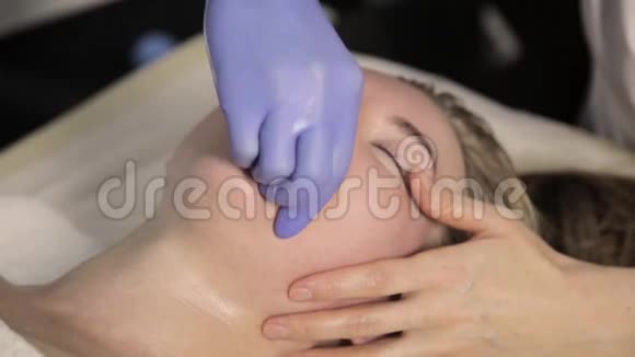 轮廓塑料美容师在美容院为美女做唇部按摩视频的预览图