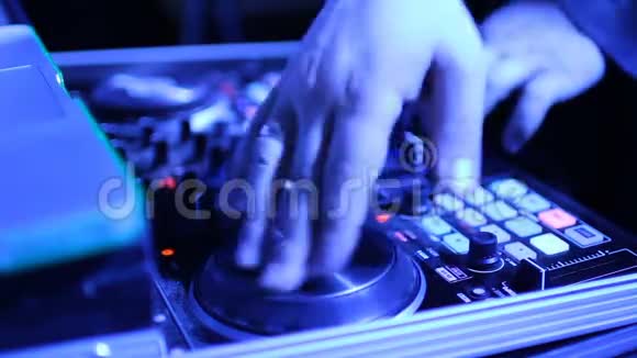 手的DJ调整各种轨道控制在DJ的甲板上视频的预览图