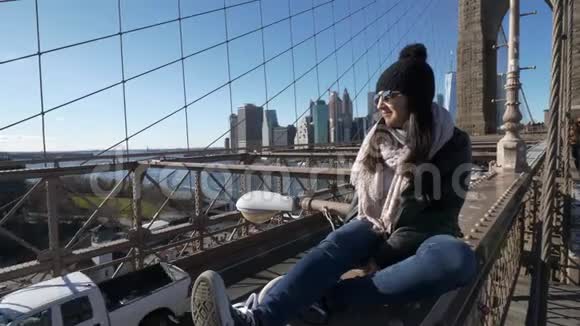 年轻鲁莽的女孩坐在纽约布鲁克林大桥边上视频的预览图