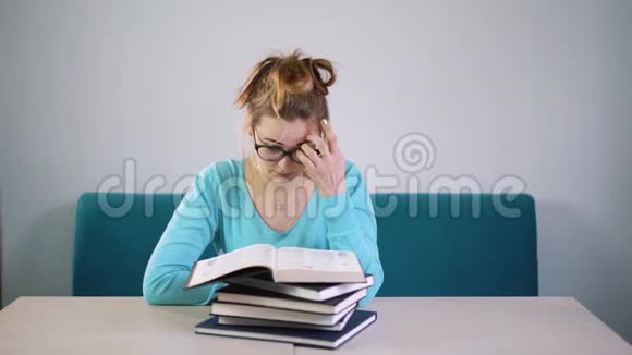 疲惫愤怒精疲力竭的学生低下头看一叠书你得读很多书很多工作闭嘴视频的预览图