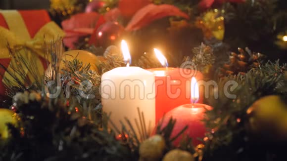 晚上在圣诞花环上点燃三支蜡烛的特写4k视频视频的预览图