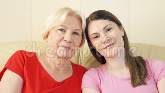 母亲和女儿在家里沙发上放松的肖像快乐的家庭一起享受视频的预览图