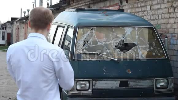 一名男子检查一辆破车小客车保险视频的预览图