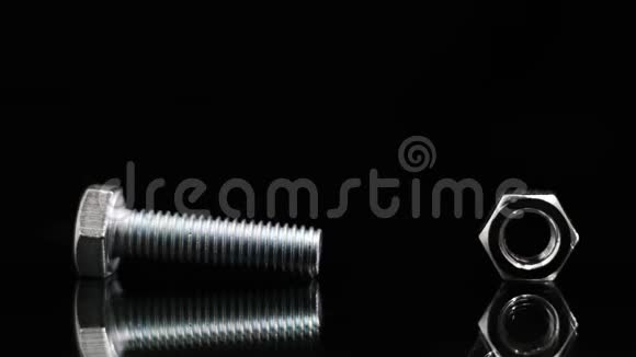 黑色背景上带螺母的金属螺栓施工理念修补视频的预览图