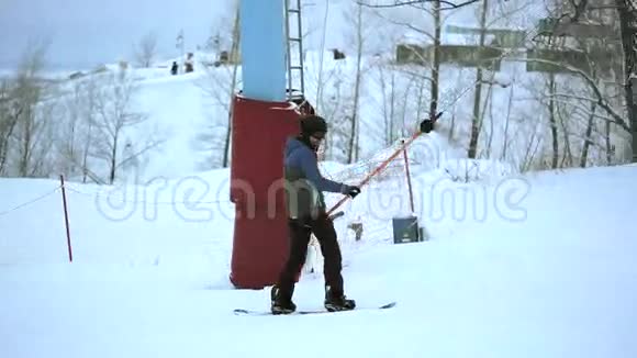 年轻运动员在斜坡上的滑雪板上用T杆举升视频的预览图