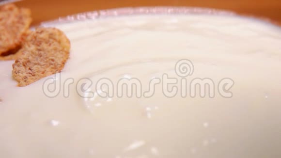 麦片和酸奶一起掉进玻璃碗里视频的预览图