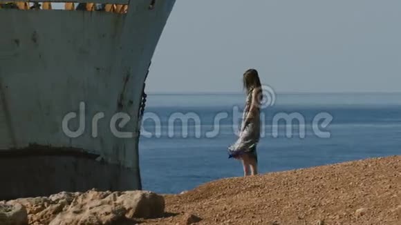 穿着漂亮的女孩喜欢海边的废弃船只视频的预览图