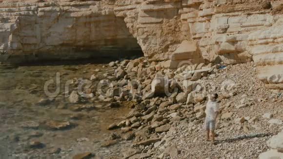英俊的男子手挽着手在岩石海岸视频的预览图