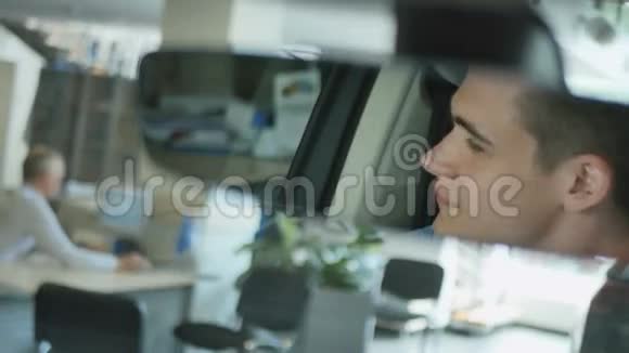 年轻人在车里看后视镜竖起大拇指视频的预览图