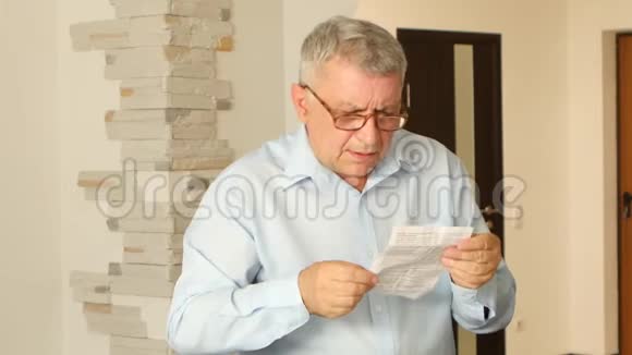 白发苍苍的男人用他那可怜的视力读说明书视频的预览图