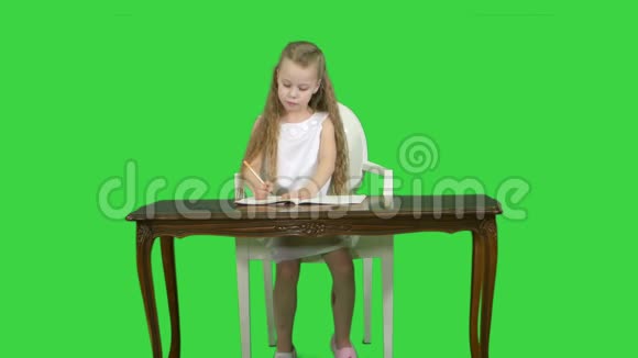 可爱的小女孩做作业写在绿色屏幕上色度键视频的预览图