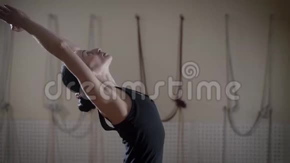 一位穿着运动服的年轻女子在垫子上做瑜伽运动视频的预览图