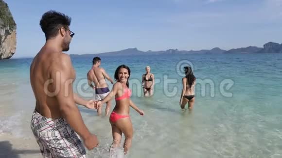 女人牵着男人的手把他带到海滩上的人们游客在海上度假视频的预览图