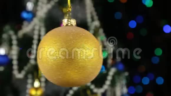 美丽的黄色新年和圣诞装饰球沉重地摆动在绳子上视频的预览图