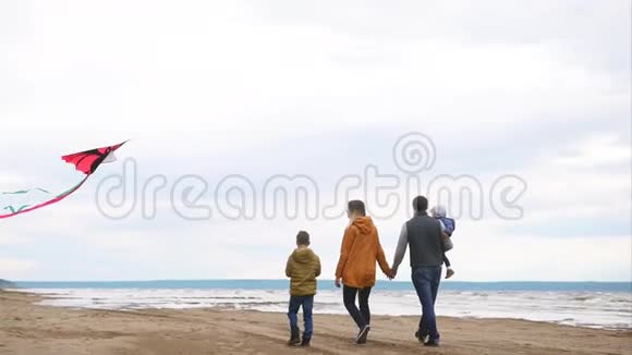 在寒冷的天气里家人在海滩上郊游视频的预览图