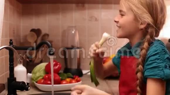快乐的小女孩在厨房的水槽里唱歌视频的预览图