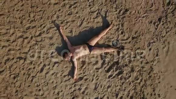 穿海星造型的人躺在沙滩上晒日光浴视频的预览图