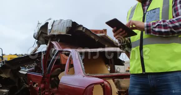 4k垃圾场使用数字平板电脑的男性工人视频的预览图
