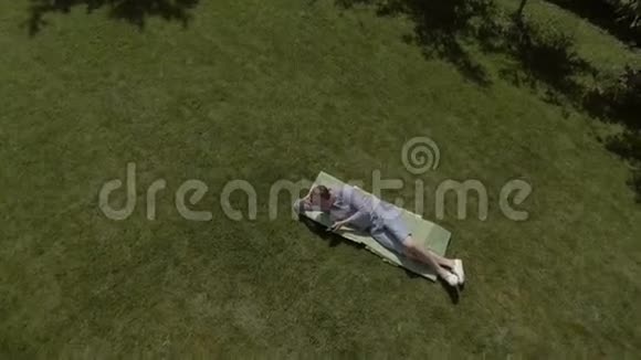 男人躺在花园的草坪上用电话视频的预览图