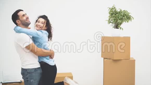 年轻夫妇一起搬到了一间新公寓他们拥抱着依偎着微笑的一对4K视频的预览图
