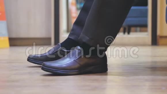 穿着棕色新时尚鞋的男性脚商人在鞋市场购物慢动作3840x2160视频的预览图