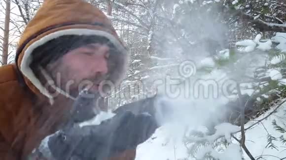 英俊的男人玩雪快乐的男人从你的手心吹雪视频的预览图