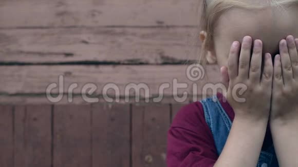 小女孩在木制背景下哭泣视频的预览图