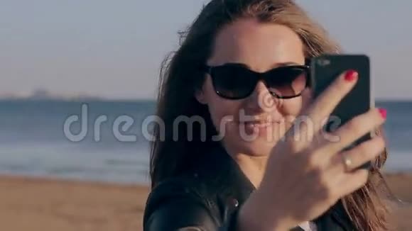 暑假海滩旅游科技和人的概念与微笑的女人自拍与智能手机在海滩视频的预览图