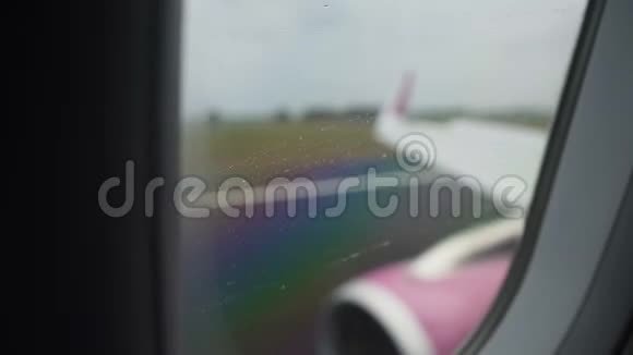 飞机机翼和发动机在跑道摇晃着陆时透过雨窗看到视频的预览图