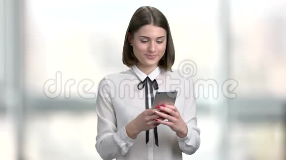 微笑商务女士使用她的智能手机视频的预览图