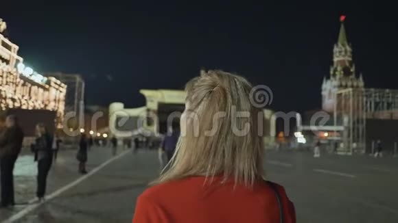 女孩走着欣赏莫斯科的夜红广场和克里姆林宫视频的预览图