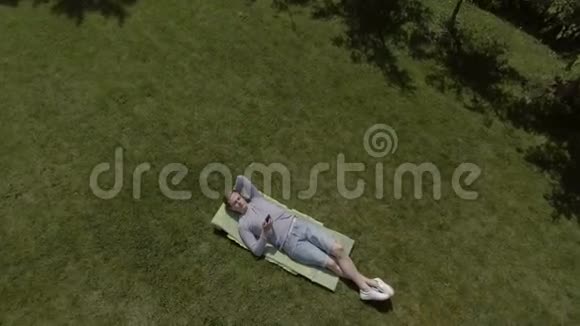 可爱的雄性在花园的草坪上休息视频的预览图