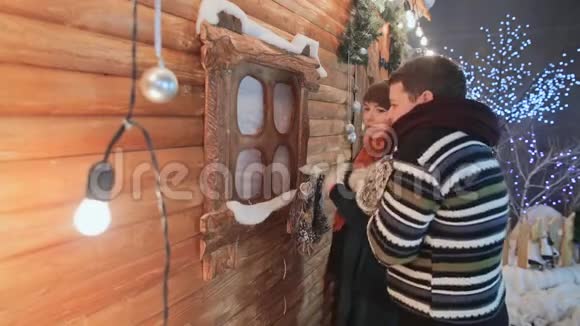 恋爱中的一对夫妇冻住了敲着一座木制童话屋的窗户让他们进来圣诞节和新年视频的预览图