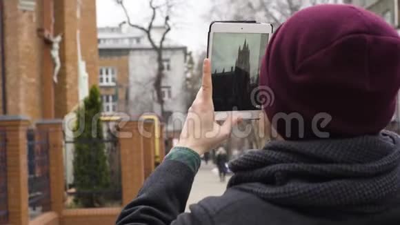一个年轻人拿着一块石碑给教堂拍照视频的预览图