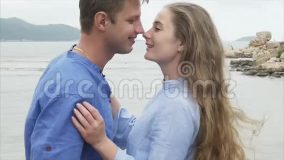靠近男人抚摸着一个女孩的头发拥抱和亲吻她一对恋人在海上休息视频的预览图